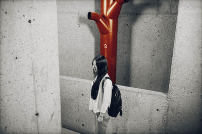 Rear view of woman walking against wall