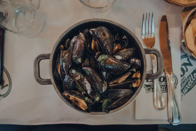 Pot of mussels on a table inside chez leon, a family-owned restaurant in brussels, belgium.