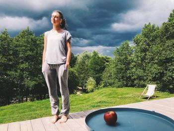 Full length of woman standing by ball against sky