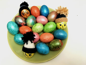 High angle view of multi colored eggs on white background