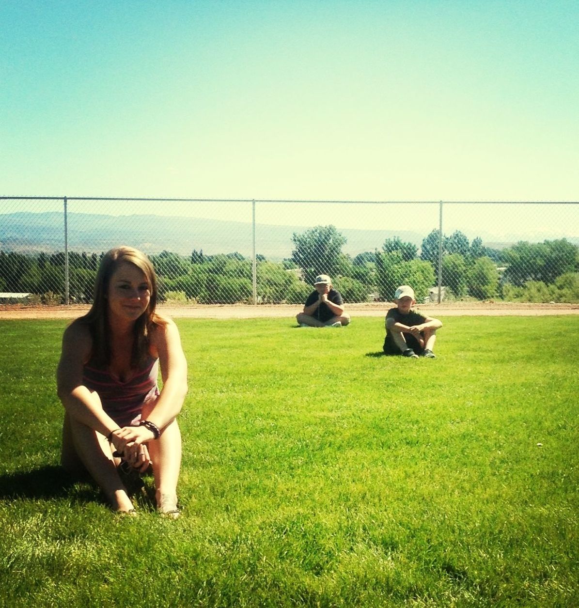 grass, leisure activity, field, lifestyles, grassy, clear sky, young adult, green color, person, sitting, togetherness, smiling, copy space, young women, casual clothing, relaxation, landscape