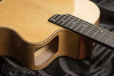 High angle view of guitar on bed