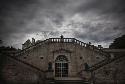 Low angle view of building against cloudy sky