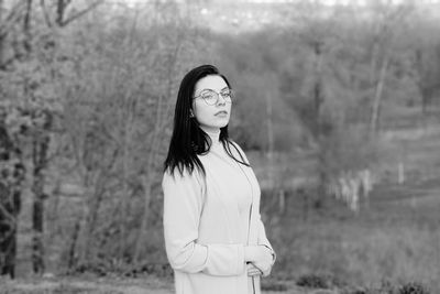 Portrait of young woman standing on field