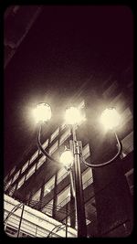 Low angle view of illuminated street light against sky