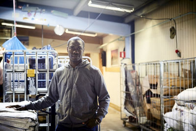 Portrait of confident mid adult volunteer standing in warehouse