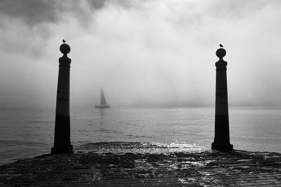 Lighthouse by sea against sky