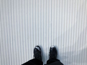 Low section of person standing on tiled floor