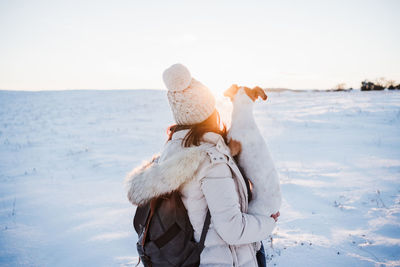 Woman wearing hat on snowy land against sky