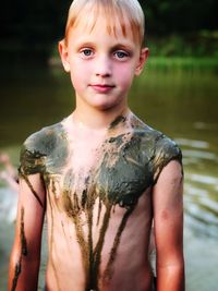 Portrait of shirtless boy standing outdoors
