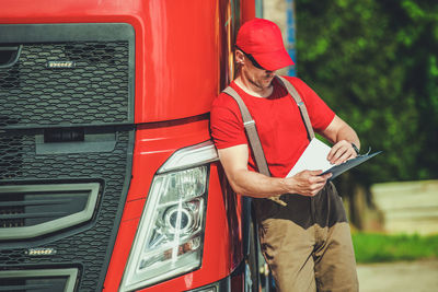 Side view of man working in car