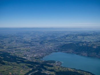 Aerial view of sea and cityscape against clear sky