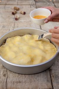 Close-up of hand holding soup in bowl on table