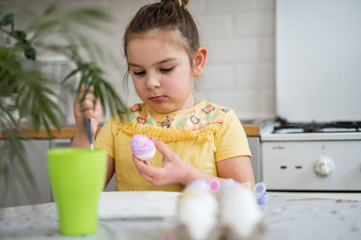 Portrait of cute girl eating food at home