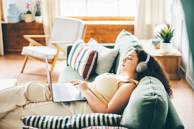 Midsection of woman sitting on bed at clinic