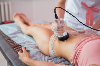 Midsection of woman lying down on bed