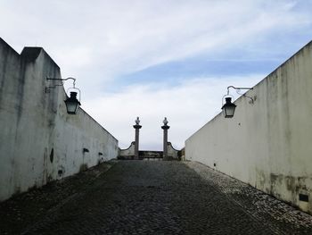 Footpath amidst buildings against sky