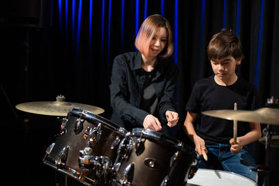 Teacher teaching boy drumming