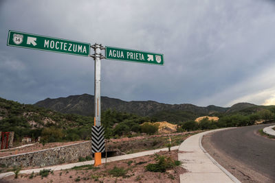 Road signs on landscape against sky