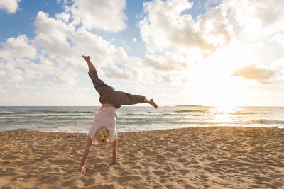 Full length of senior woman on beach against sky