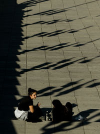 High angle view of friends sitting on steps during sunny day