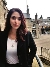 Portrait of beautiful woman standing against building