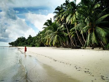 Woman standing on beach during sunny day