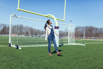 Full length of woman standing on soccer field