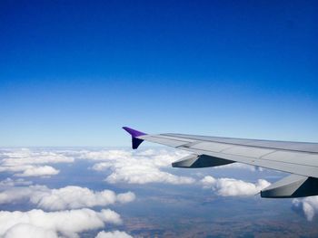 Airplane flying over clouds against blue sky