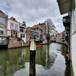 Canal amidst buildings against sky