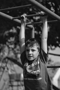 Boy hanging on railing in playground