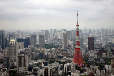 Aerial view of buildings in city against cloudy sky