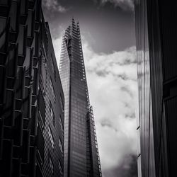 Low angle view of shard london bridge against cloudy sky