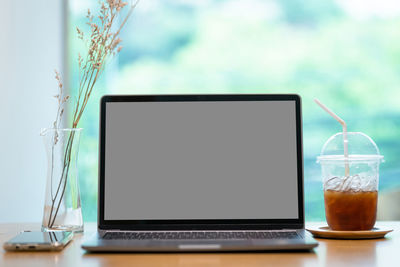 Glass of laptop on table