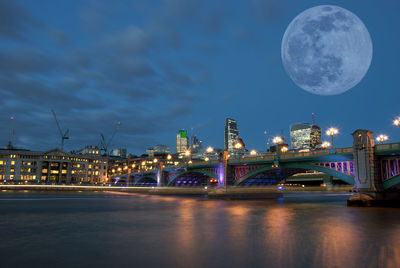 A full moon over southwark bridge from the south bank of the river thames in london, uk