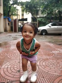 Cute baby girl standing on footpath