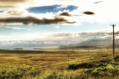 Scenic view of field against cloudy sky