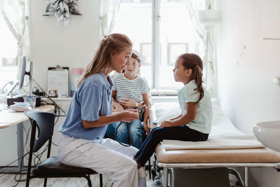 Female pediatrician talking with girl during medical checkup at clinic