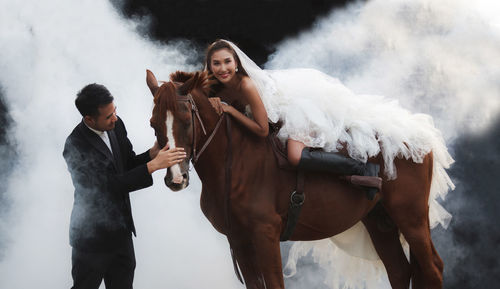 Wedding couple with horse at farm