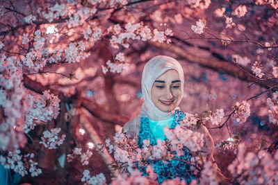 Portrait of a smiling young woman with cherry blossom