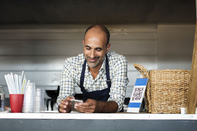 Vendor using smart phone while standing in food truck