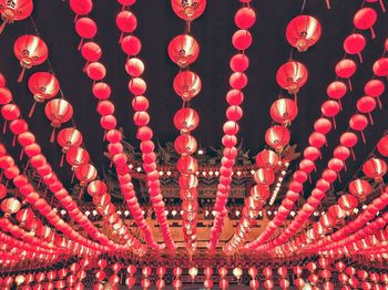 Low angle view of illuminated lanterns hanging at night