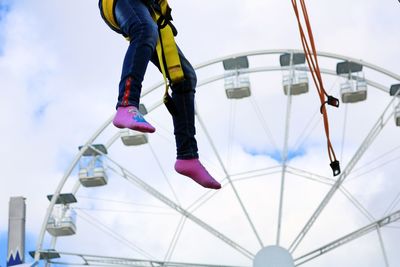 Low section of man by ferris wheel