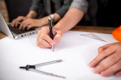 Close-up of hand using mobile phone on table