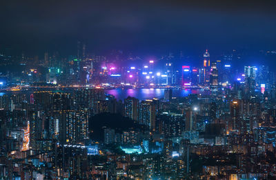 Illuminated city against sky at night