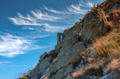 Low angle view of rocky mountains against sky