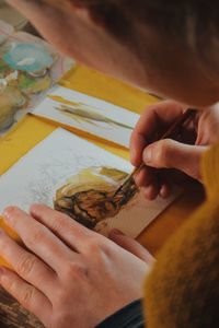 Close-up of woman drawing in paper on table