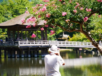 Rear view of person standing by lake