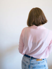 Rear view of woman standing against wall