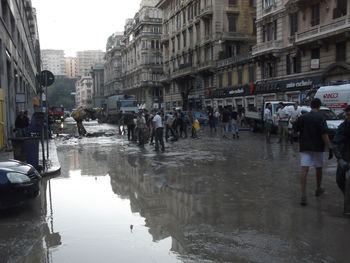 People on wet street in city during rainy season